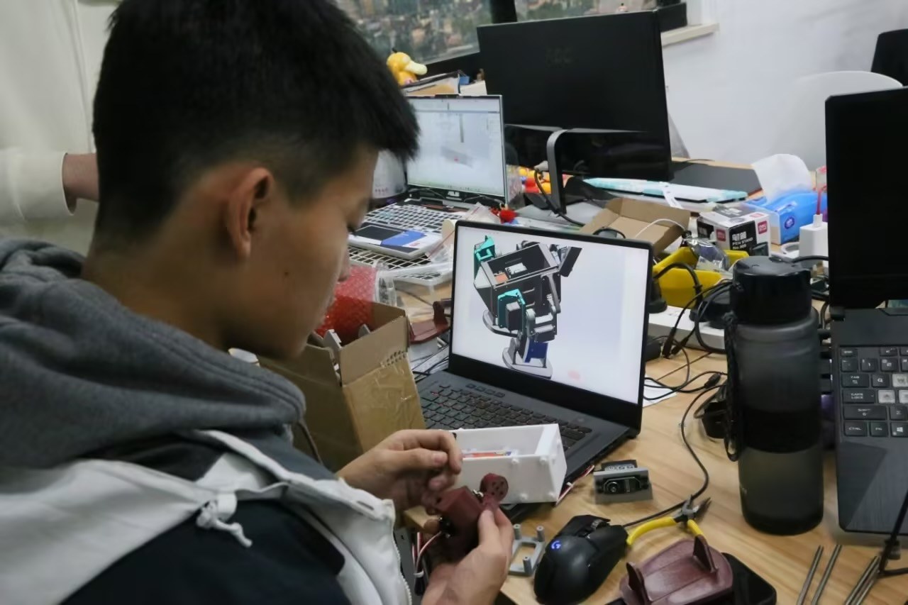 Winson working on the mechanical design at his desk