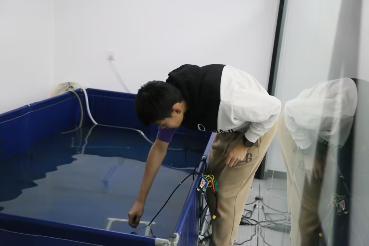 Winson testing the amphibious drone prototype in a pool